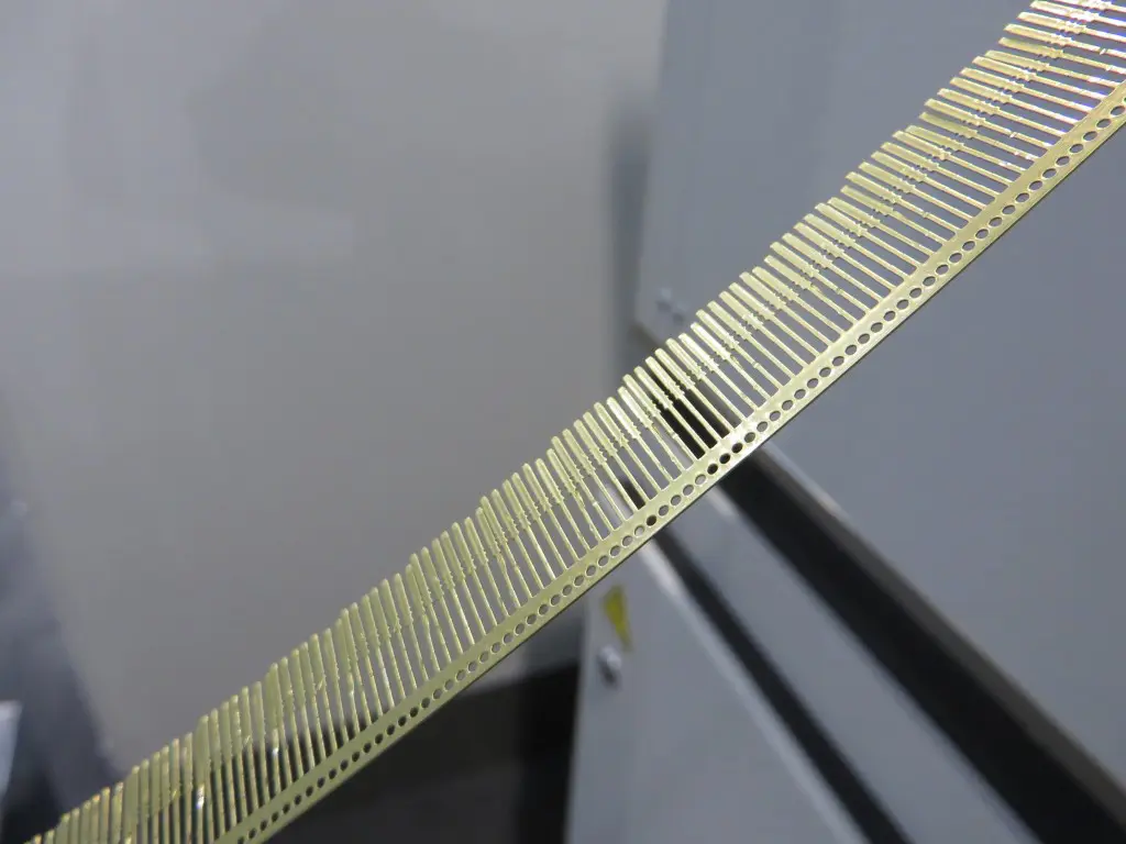 Het bewerkte bandmateriaal van o,25 mm dik wordt na het ponsenop een haspel opgerold (foto's: Reinold Tomberg)