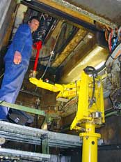 Balancer plaatst stempelveren vanuit kleine kelder onder pers featured image